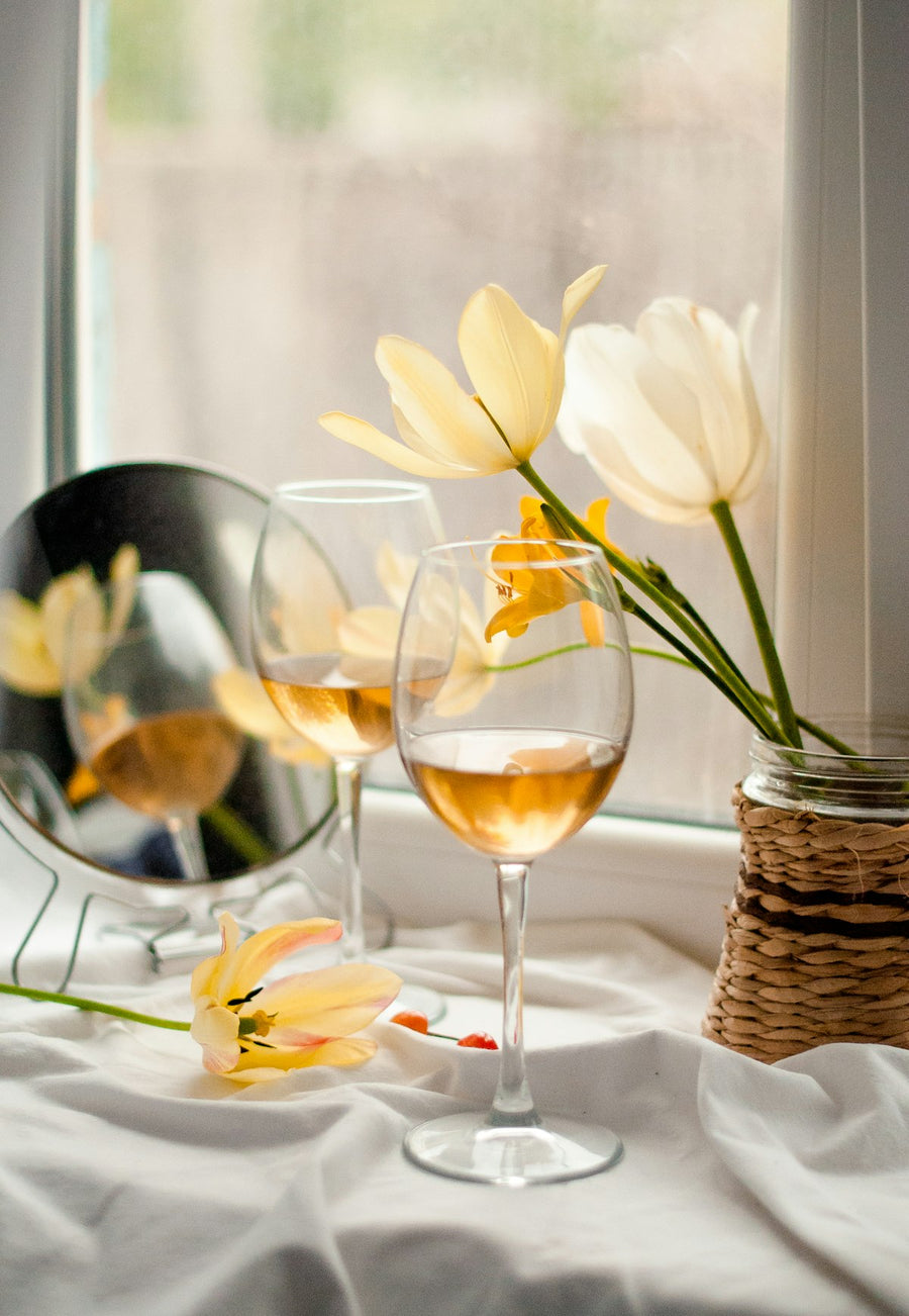 Copas de vino blanco junto a flores